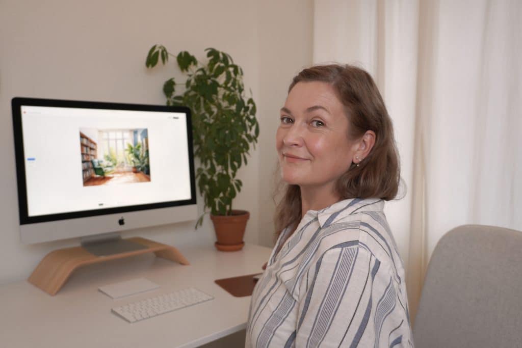 Maja Larsson ler mot kameran. På datorskärmen bakom henne visas en AI-genererad bild.