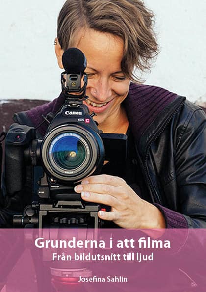 Josefina Sahlin står med videokamera som pekar rakt fram mot grå/blå vägg