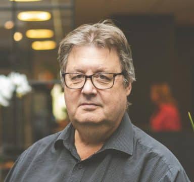 Göran Husman sitter vid soffa i Göteborgskontoret