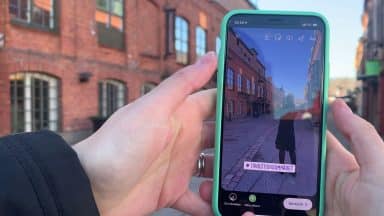 Person tar en bild med sin mobil och ska lägga till plats på Instagram med en platstagg.