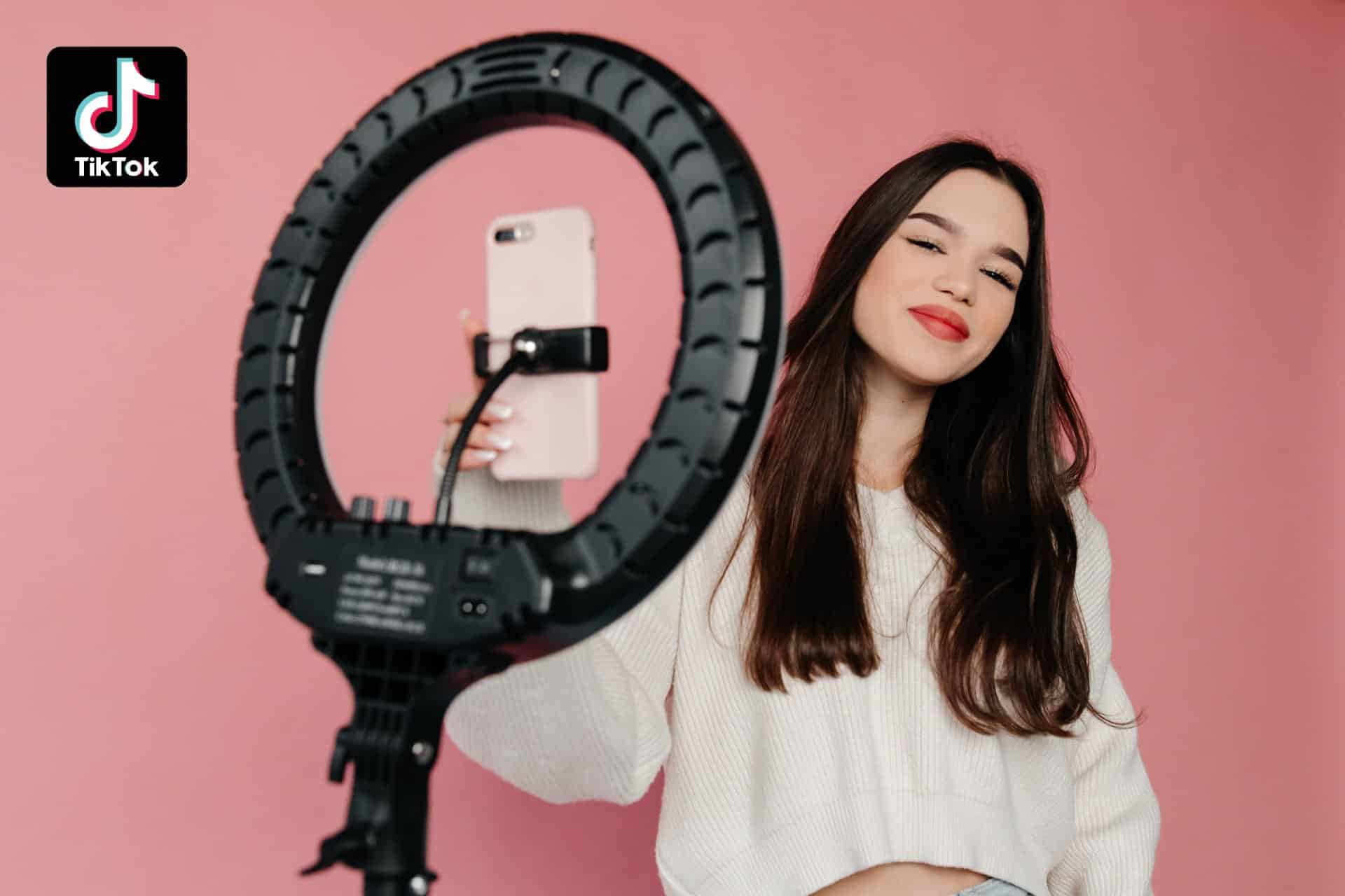 kvinna som filmar sig själv med mobiltelefon och ringlight