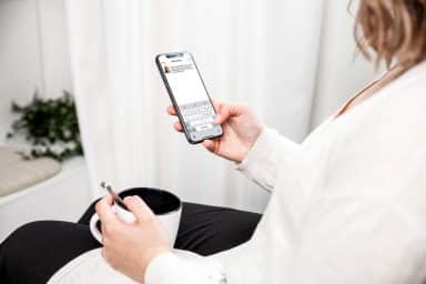 kvinna sitter med mobilen i handen, skriver alt-text på Instagram.