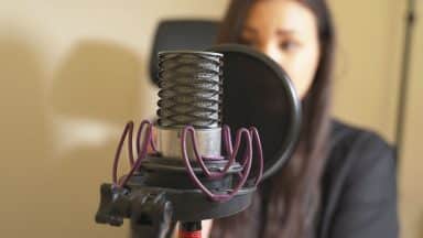 Person spelar in vid en studiomikrofon