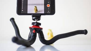 En mobil på stativ som fotograferar ett äpple