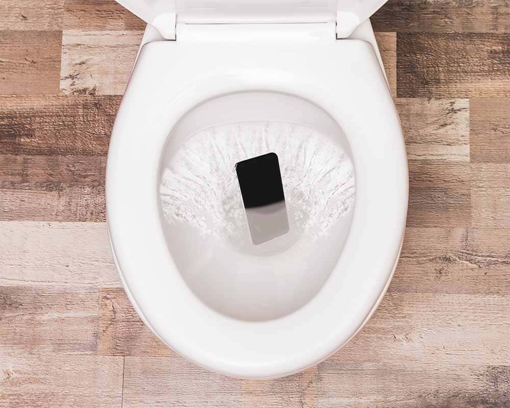 Bild på en iphone som spolas ner i toaletten