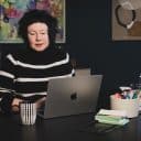 Sanna Lund sitter med en laptop på ett skrivbord och chattar med ChatGPT.