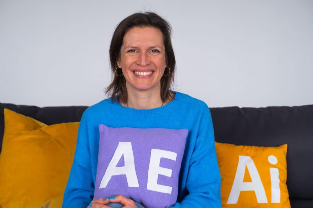 Anna Jadvi sitter i soffan och håller i en After Effects-kudde.