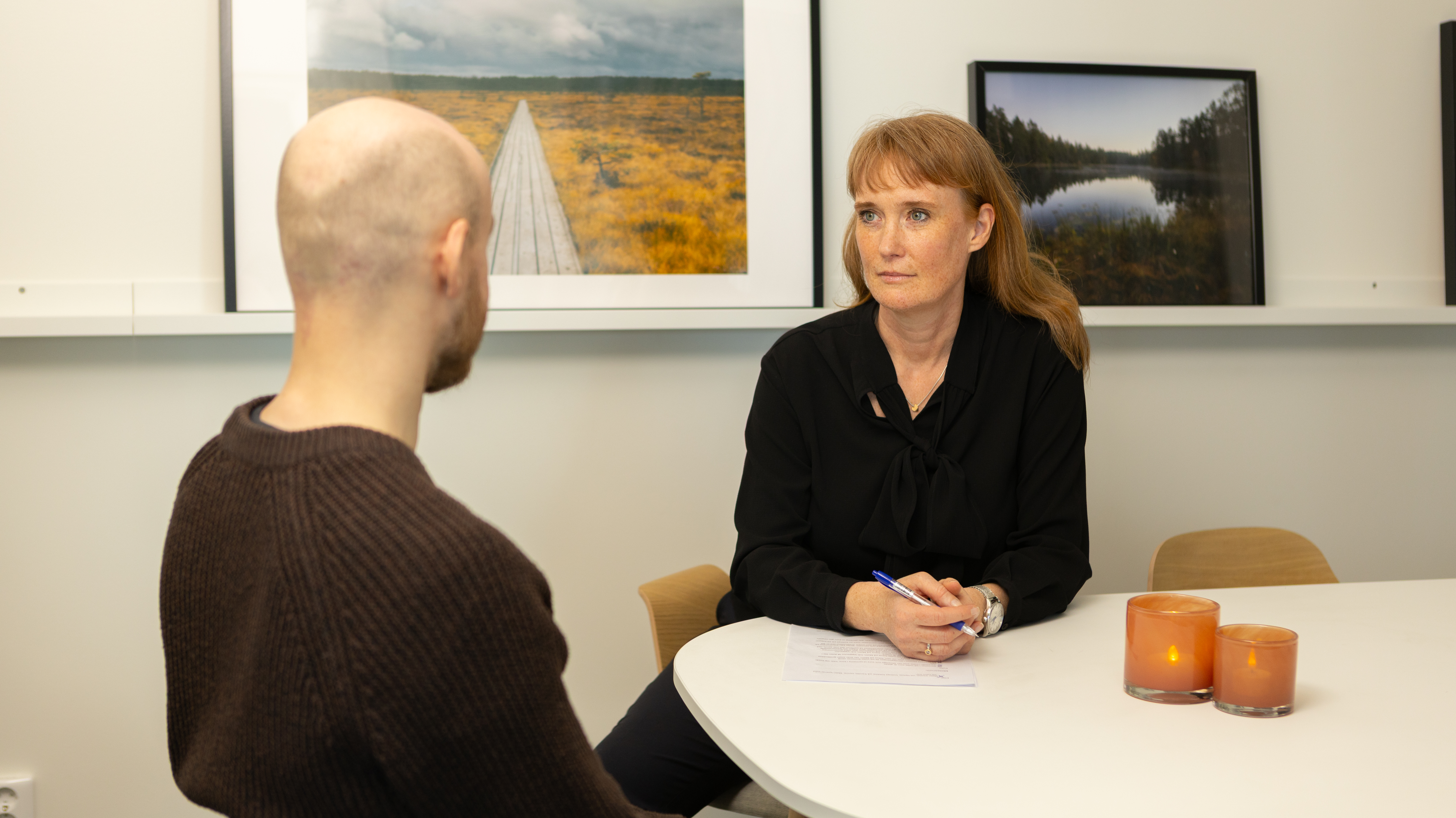 Två personer i ett mötesrum som ger och tar feedback.