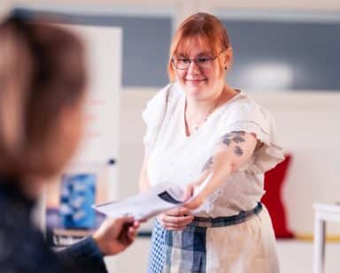 Medarbetare ger tar emot en rapport.