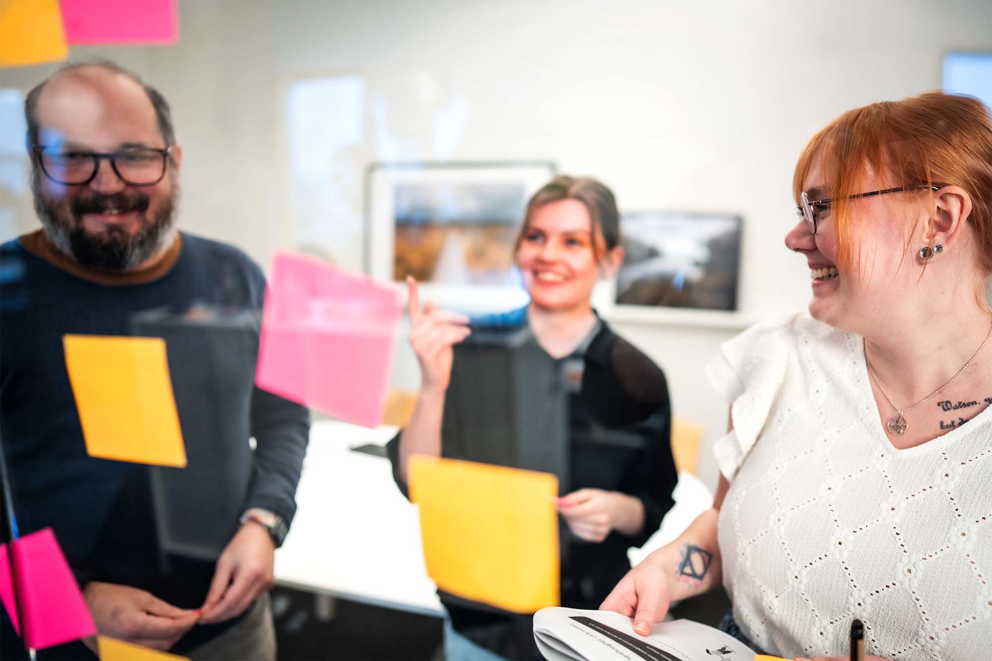 Tre medarbetare brainstormar tillsammans.