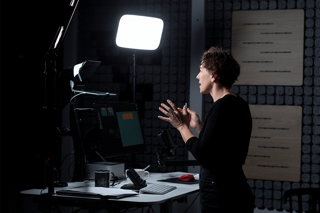 Josefina Sahlin håller i ett webbinar i studio framför kamera, ljus och skärmar.