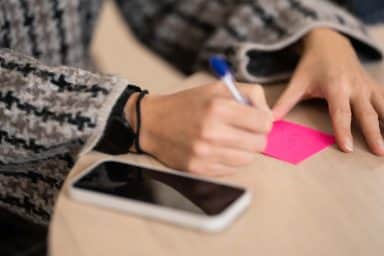 Medarbetare skriver på en postit