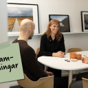 Tre människor sitter i ett mötesrum och arbetar med en övning för feedback.