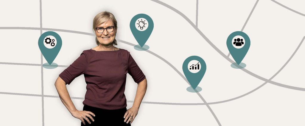 Kvinna ler framför en karta med platsmarkörer som har grafik för statistik, människor, kugghjul och glödlampa.